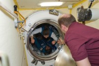 Expedition 23 Kommandant Oleg Kotow hilft Tracy Caldwell Dyson durch die Luke an Bord der Raumstation