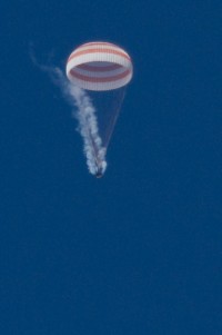 spektakuläre Aufnahme von Sojus TMA-07M am Fallschirm, während gerade der Resttreibstoff abgelassen wird