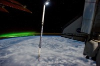Canadarm mit OBSS, im Hintergrund ein Polarlicht