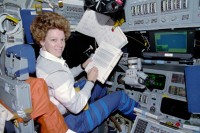 Eileen Collins beim Studium von Unterlagen im Cockpit der „Atlantis“